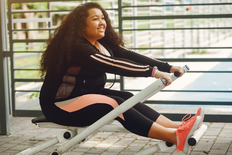 A smiling lady doing healthy play on durable outdoor gym equipment