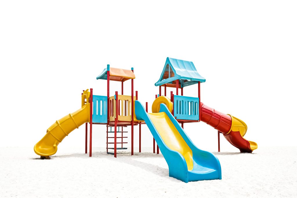 Colorful playground with two towers, ladders, and yellow, blue, and red slides on white sand