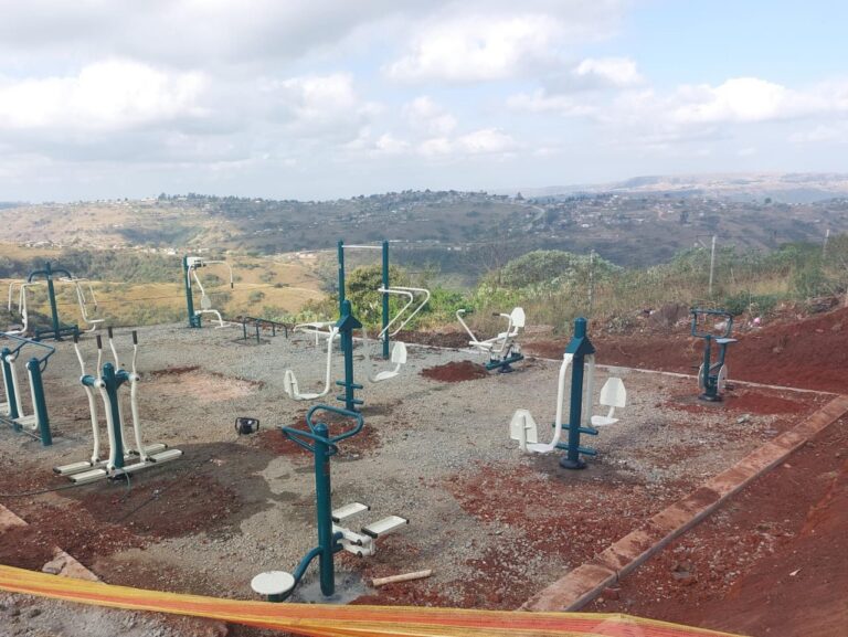 Outdoor gym with many exercise stations on a hillside overlooking a valley