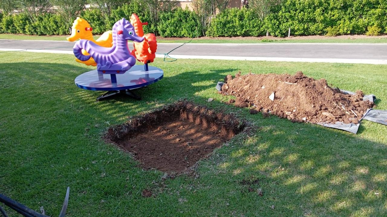 Spring riders on a lawn with foundation pits dug during installation